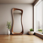 May include: A large, free-standing, wooden mirror with a unique, wavy, organic shape. The mirror is in a room with a wooden floor and a window with a view of a city skyline.