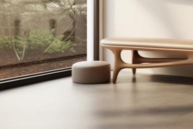 May include: A light brown wooden bench with a curved design and a light brown cushioned seat. A small, round, light brown ottoman sits in front of the bench.