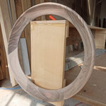May include: A round wooden frame made of walnut wood with a natural wood finish. The frame is being used to create a circular opening in a piece of wood.