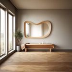 May include: A wooden bench with a curved design and a wavy mirror above it. The bench has a shelf and is sitting on a light wood floor.