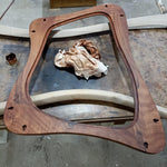 May include: A stained wooden frame with a unique, curved design. The frame is a warm brown color and features several pre-drilled holes. A crumpled cloth and a small container are also visible.