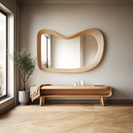 May include: A wooden bench with a curved design and a shelf underneath. The bench is in front of a large, wavy, wooden framed mirror.