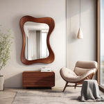 May include: A walnut-framed mirror with an organic, wavy shape hangs above a matching wooden dresser. The room features a neutral color palette, a modern armchair, and a pendant light, creating a serene and stylish interior.