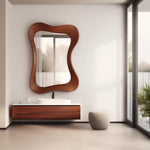 May include: A modern bathroom with a large, organically shaped wooden mirror. The mirror hangs above a floating vanity with a white countertop and a dark wood cabinet. A small, rounded stool sits nearby. The room has large windows.