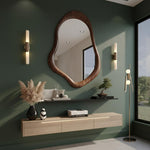 May include: A modern interior with a large, organically shaped wooden mirror as the focal point. The room features a floating wooden cabinet, a black shelf with decor, and a floor lamp. The walls are painted a deep green, creating a sophisticated ambiance.