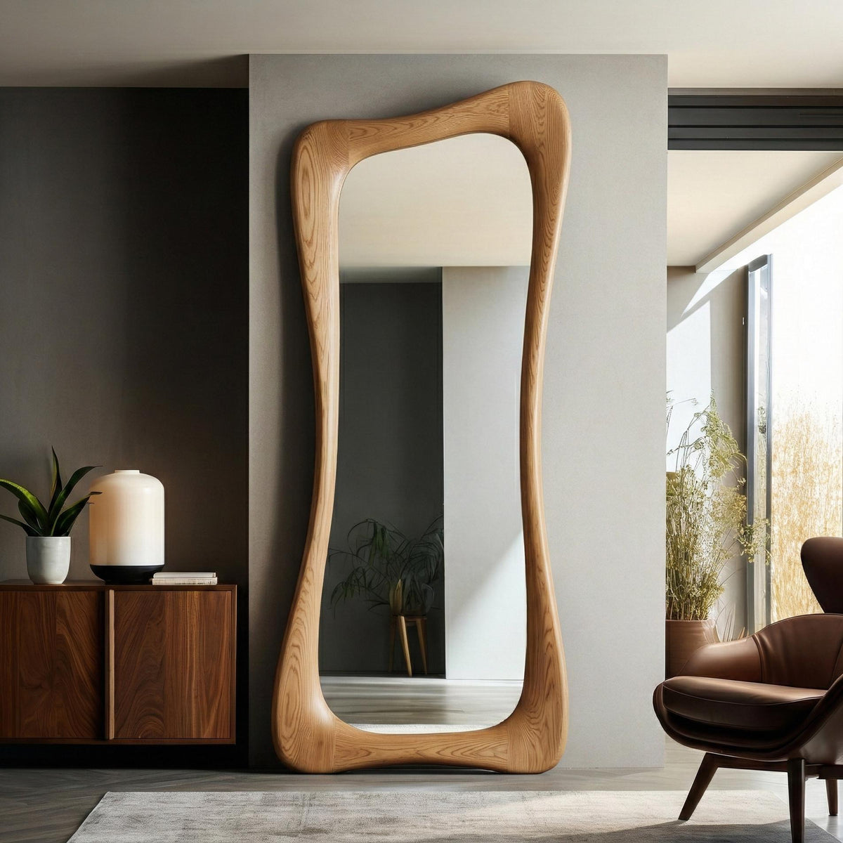 May include: A full-length, free-standing mirror with a unique, organic wooden frame. The frame has a light brown finish and an undulating, curved shape. The mirror is positioned against a neutral-colored wall, reflecting the room. The overall style is modern and minimalist.