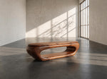 May include: A modern, oval-shaped wooden coffee table with a unique cutout design. The table is made of dark brown wood and sits low to the ground. The table's dimensions are approximately 50 inches long and 20 inches wide.