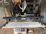 May include: A black, modern-style coffee table with an oval top and unique, open-work legs. The table is approximately 72 inches long and sits on a light-colored surface. The design features a blend of curves and angles.