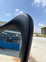 May include: Close-up of a curved, black wooden chair arm. The wood grain is visible, and the finish is smooth and glossy. The chair arm is part of a larger piece of furniture, likely a chair or a bench.