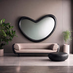 May include: A large, black, heart-shaped wall mirror hangs above a light beige sofa with rounded black armrests. A low, round, black coffee table sits in front of the sofa. Two potted green plants are positioned on either side of the furniture.